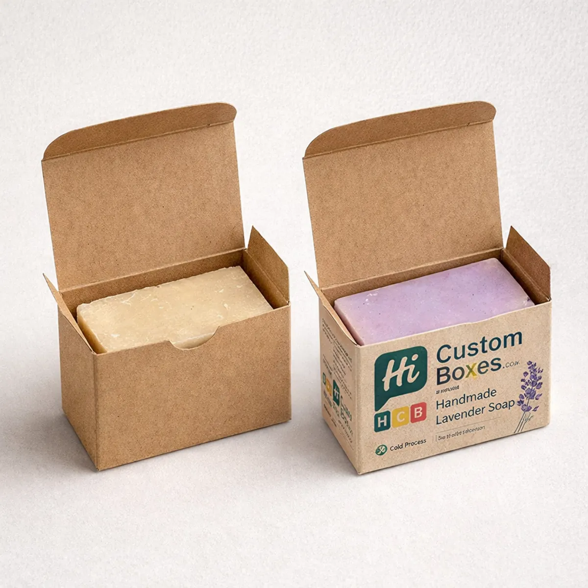 Two brown kraft paper soap boxes, one plain and one printed with lavender branding, holding bars of soap.